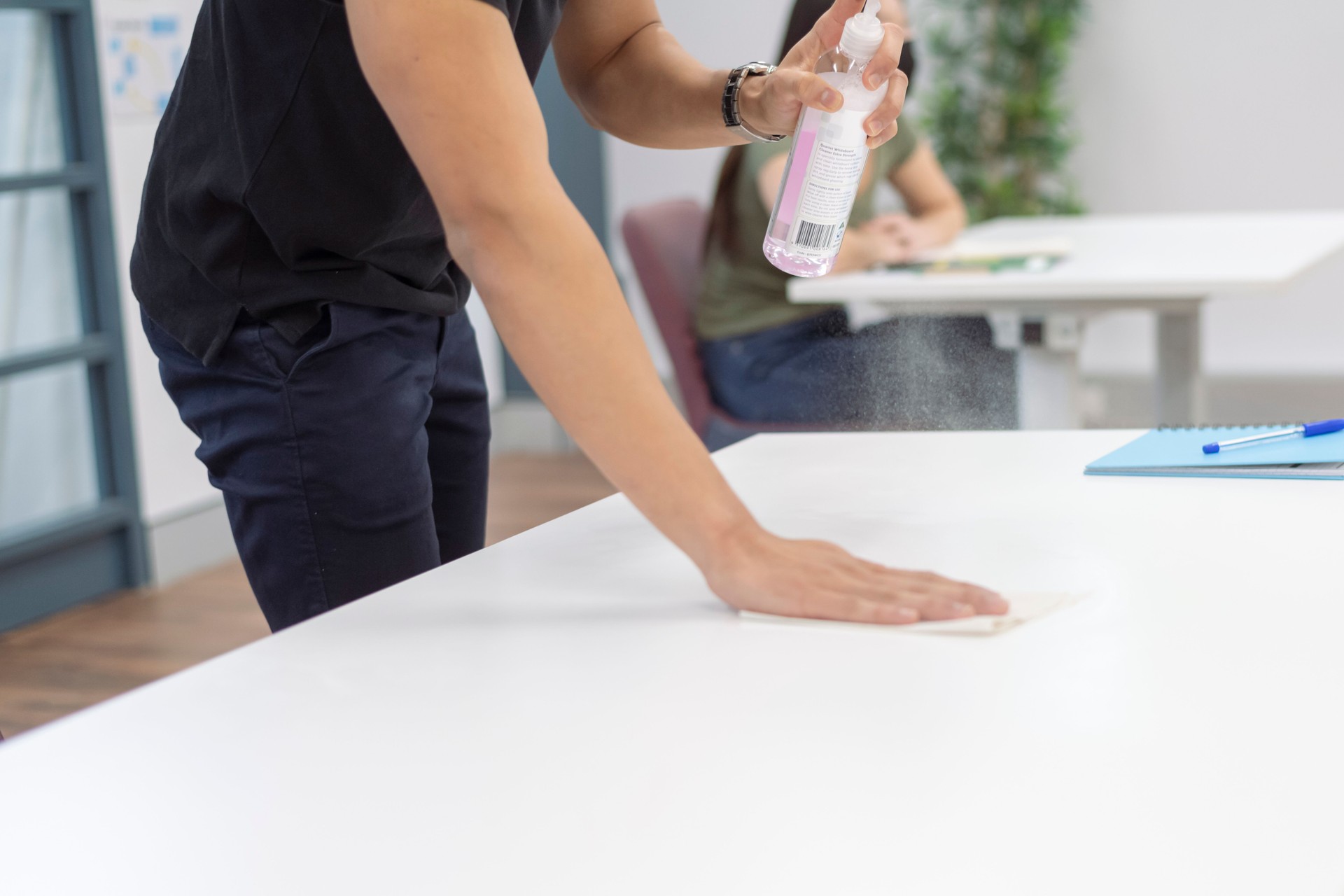 Young professional man disinfecting desk